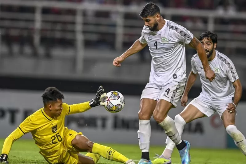 Penjaga gawang Timnas Indonesia Esyahrul Trisna Fadillah (kiri) menghalau tendangan pemain Timnas Palestina Yaser Hamed (kanan) pada pertandingan FIFA Matchday di Stadion Gelora Bung Tomo. (ANTARA)