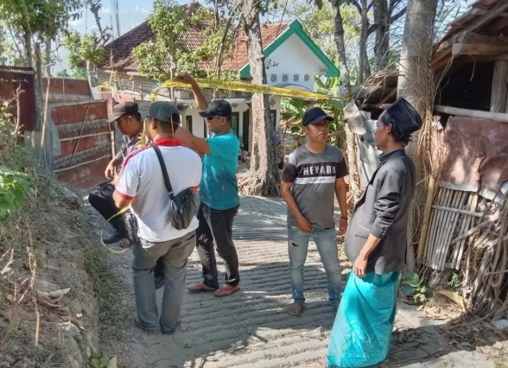 Aparat memasang garis polisi di Dusun Tengah, Desa Moncek Tengah, Kecamatan Lenteng, Sumenep, usai terdengar suara ketukan dari dalam tanah, Sabtu (12/8). (Radar Madura)