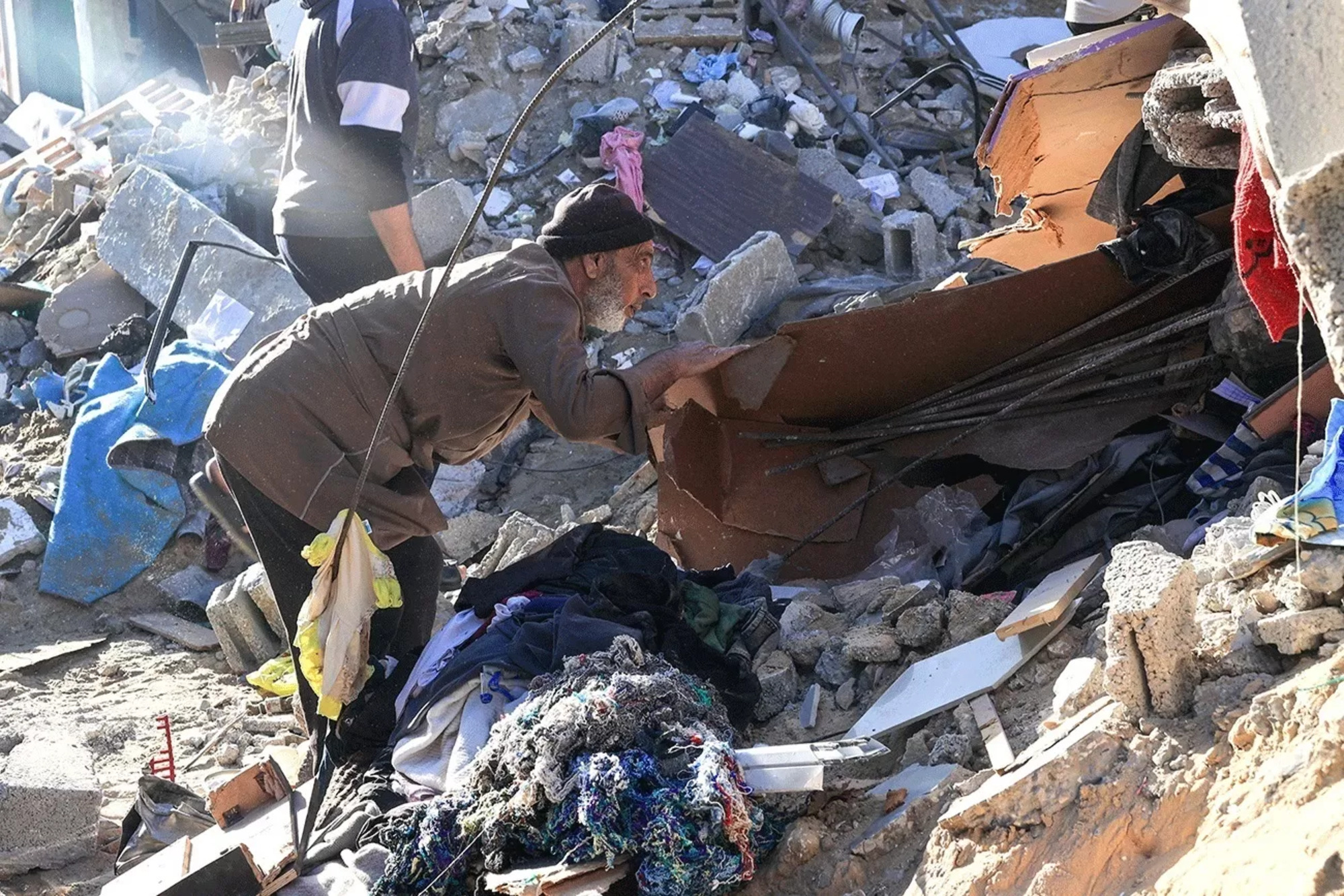 Seorang pria membongkar reruntuhan sebuah bangunan yang rusak akibat bom Israel di Rafah, Jalur Gaza Selatan, Minggu (3/12). (AFP)