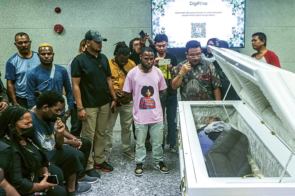TELAH LAMA SAKIT: Kerabat dan keluarga di depan peti jenazah mantan Gubernur Papua Lukas Enembe di Rumah Duka Sentosa RSPAD Gatot Subroto, Jakarta, Selasa (26/12). (SALMAN TOYIBI/JAWA POS)