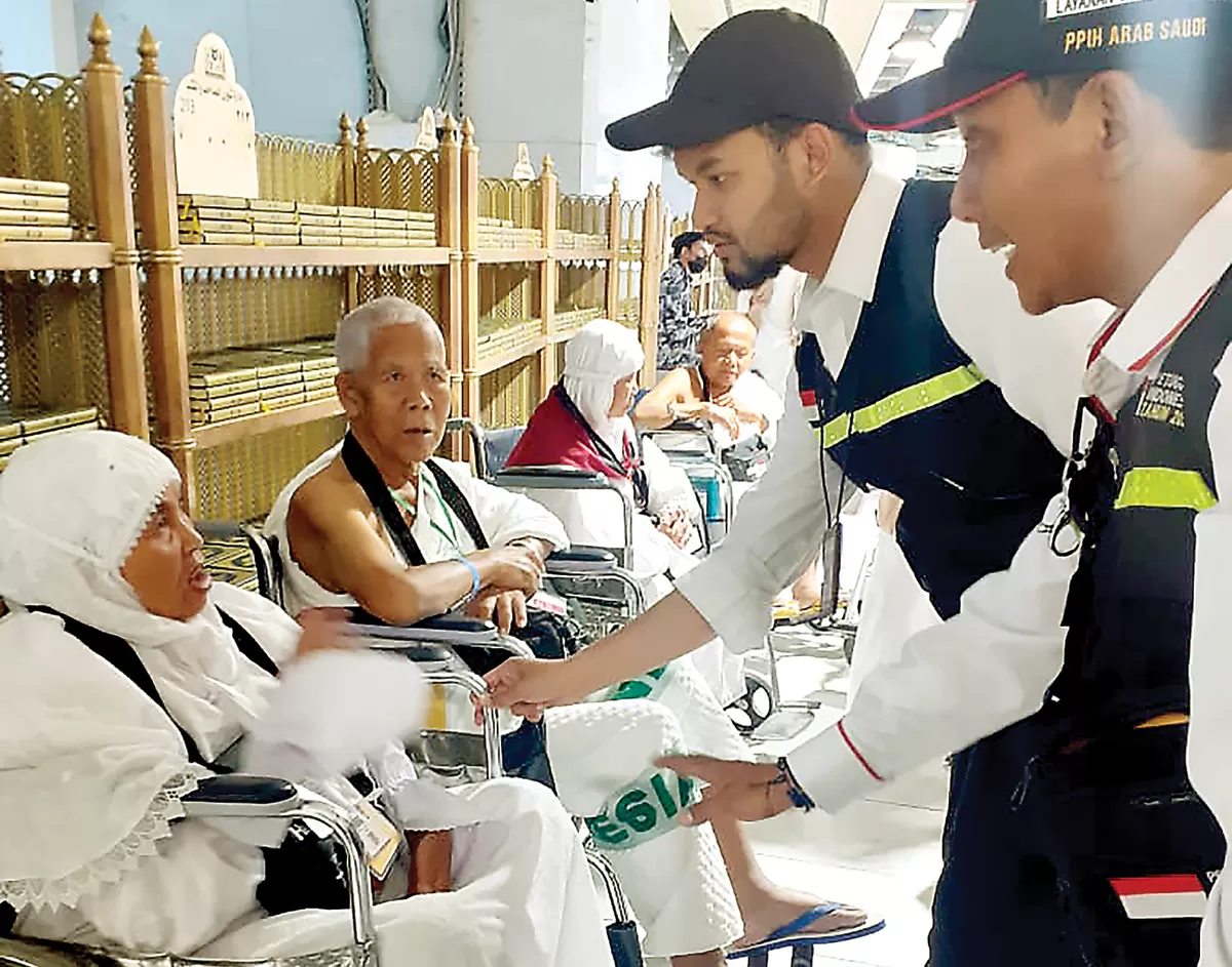 SIAP MEMBANTU: Petugas haji berkomunikasi dengan jemaah lansia yang akan tawaf menggunakan jasa kursi roda di Masjidilharam, Minggu (4/6). (MEDIA CENTER HAJI 2023)