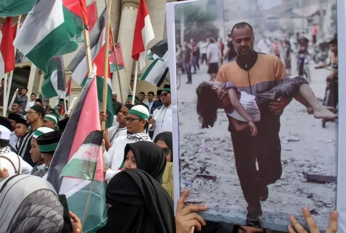 Ilustrasi aksi Bela Palestina membawa gambar korban pembantaian warga sipil Palestina. (Rahmad/Antara)