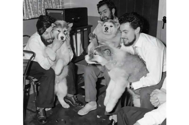 Dennis Bell (kiri) bersama rekan-rekannya dan anjing-anjing yang membantu mereka bekerja di Antartika. Pertengahan musim dingin 1959 di Pangkalan Admiralty Bay.
