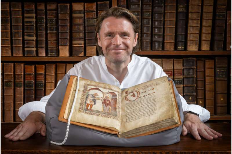 Profesor David Woodman dengan potret &AElig;thelstan di Perpustakaan Parker, Corpus Christi College, Cambridge.