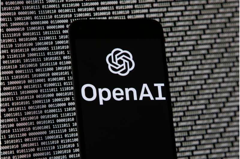 Logo OpenAI muncul di ponsel di depan layar komputer dengan data biner acak, 9 Maret 2023, di Boston.