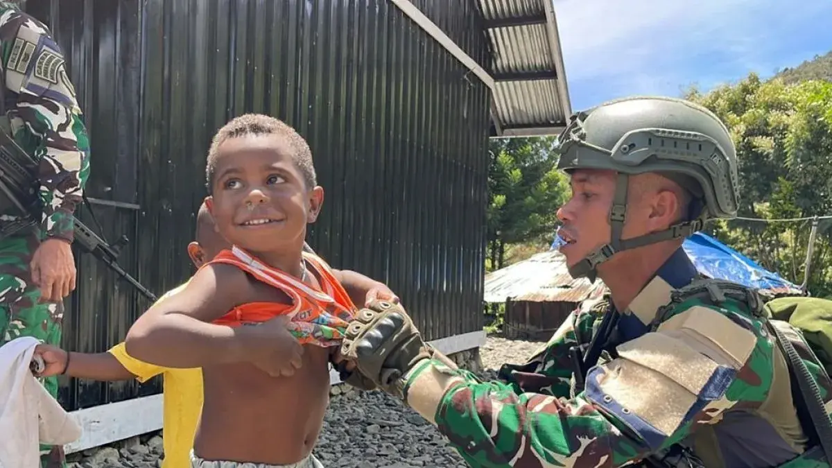 Aksi humanis prajurit TNI, balita di kampung Wiringgame, distrik Mulia, kabupaten Puncak Jaya, Papua Tengah, dipakaikan baju oleh Satgas Yonif 136/TS. (Antara/HO-Dok Satgas Yonif 136/TS)