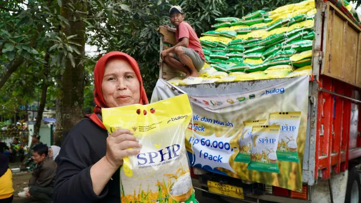 Seorang warga memegang karungan beras program SPHP kemasan 5 kilogram. (Antara/HO-Bapanas)