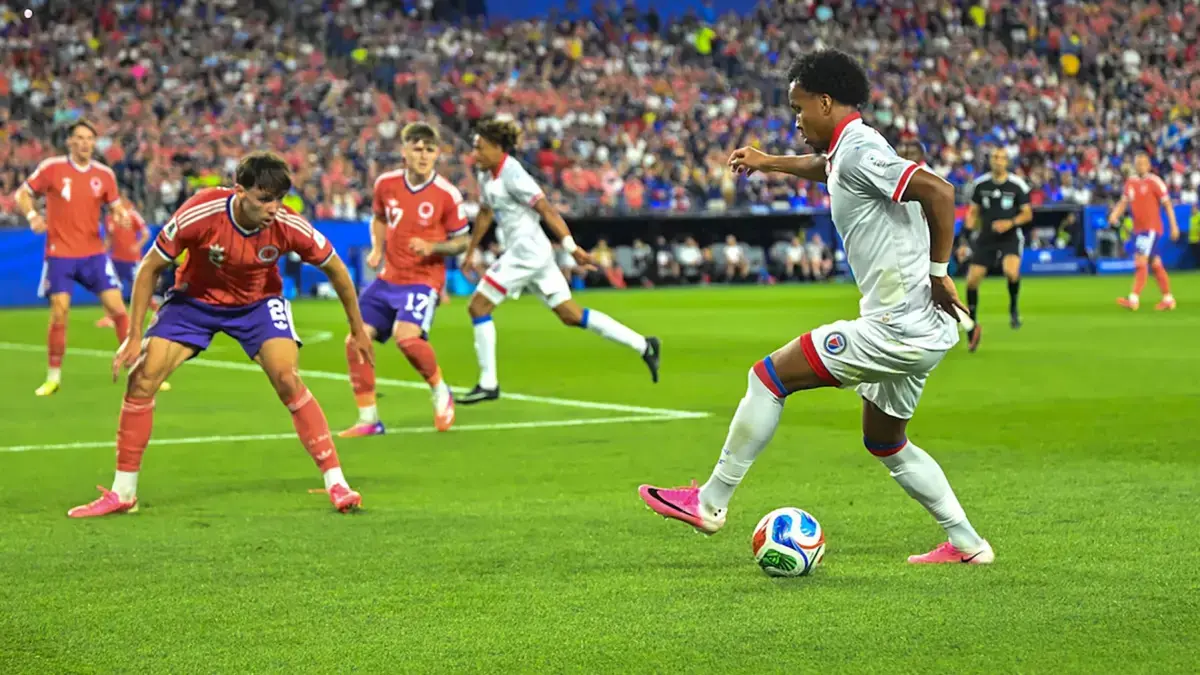 Ruben Providence dari Haiti (kanan) mencoba mengecoh Aaron Hickey dari Skotlandia dalam pertandingan Piala Dunia, Sabtu (13/6/2026) di Stadion Gillette AS. Banyak pemain mengenakan sepatu warna pink. (Dok. Sebastian Restrepo/MassLive)
