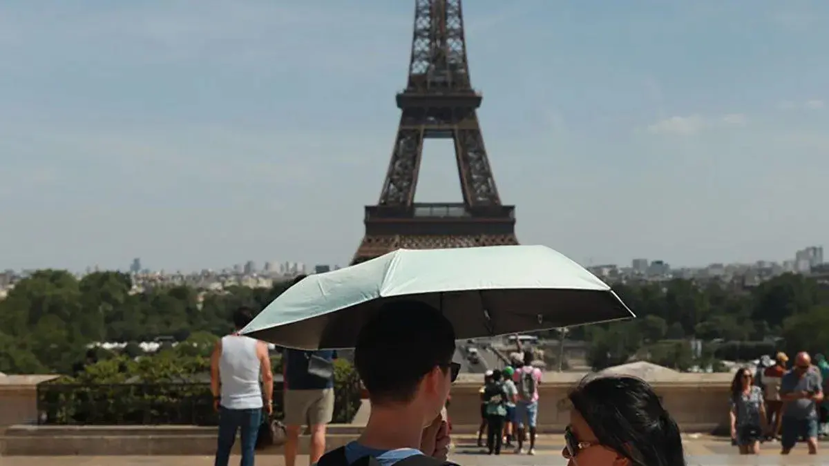 Para wisatawan yang berkunjung ke Paris berusaha melindungi diri dari sinar matahari dengan menggunakan payung akibat gelombang panas ekstrem yang melanda Eropa (25/6/2026). (ANTARA/Mohamad Salaheldin Abdelghani Alsayed - Anadolu Agency / pri)