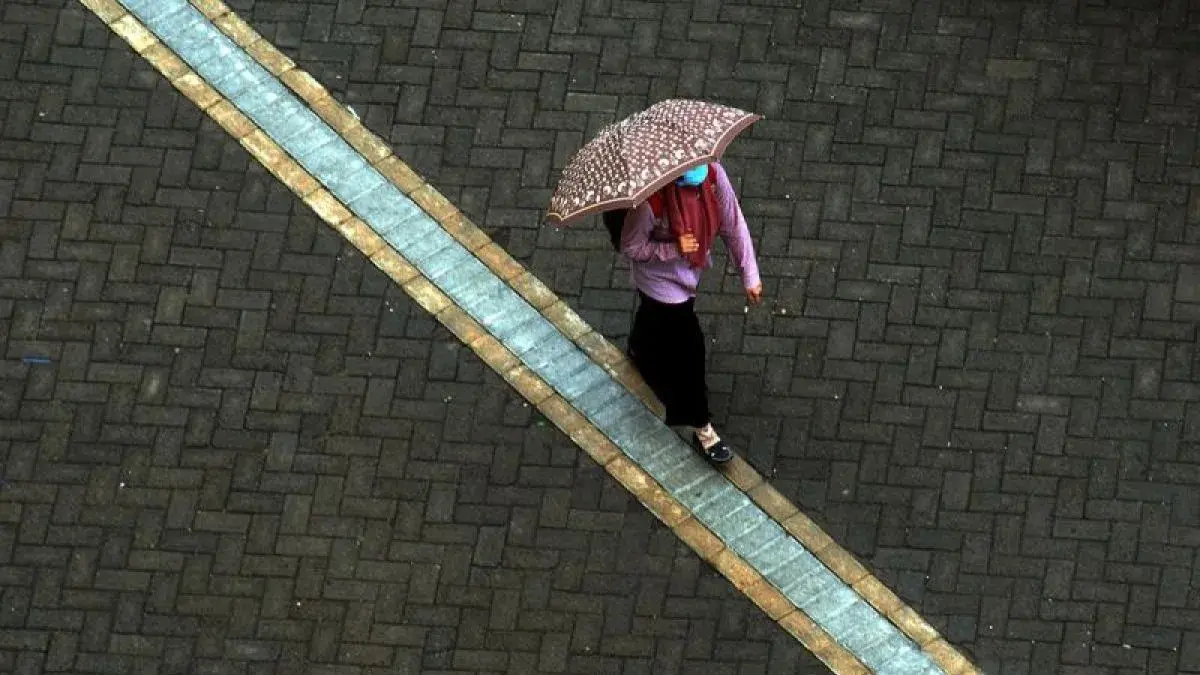 Arsip foto - Seorang warga berjalan menggunakan payung saat turun hujan di Makassar, Sulawesi Selatan, Senin (12/11/2018). (ANTARA/Abriawan Abhe)
