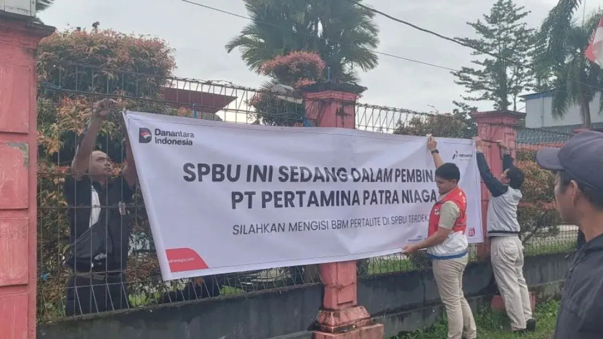 Petugas Pertamina Patra Niaga bersama Disperindag Mimika memasang spanduk pembinaan depan pagar SPBU SP2 Jalan Cenderawasih Timika, Papua Tengah, Kamis (09/07/2026). Selama 14 hari, SPBU tersebut dilarang menjual produk BBM subsidi jenis Pertalite. (ANTARA/Handayani)
