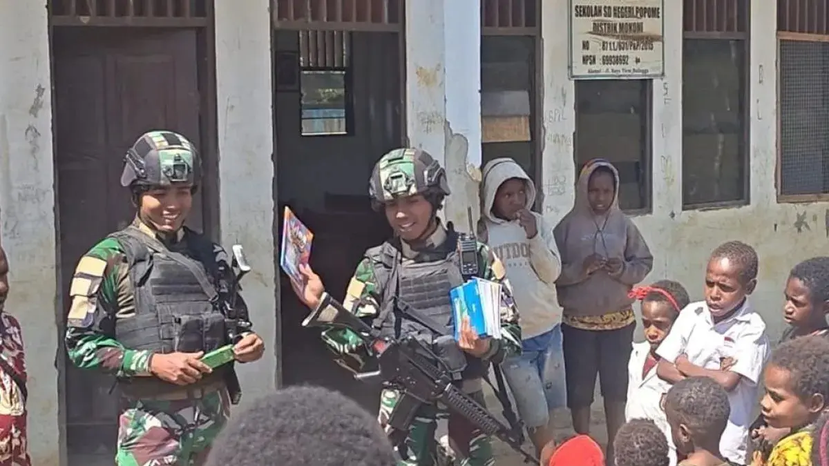 Prajurit Satgas Pamtas Yonif 511/DY membagikan alat tulis kepada siswa SD Kampung Popome, Distrik Mokoni, Kabupaten Lanny Jaya, Papua Pegunungan. (ANTARA/HO-Dok Satgas Yonif 511/DY)
