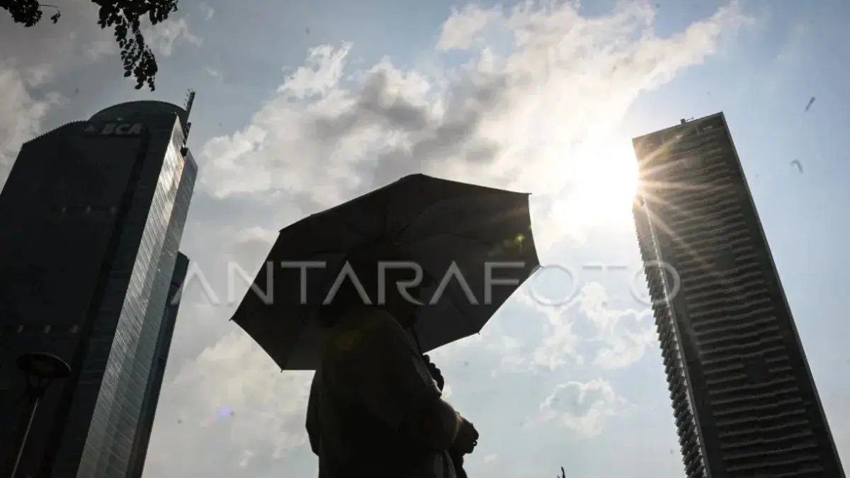 Warga menggunakan payung saat cuaca terik di kawasan Bundaran HI, Jakarta, beberapa waktu lalu. (ANTARA FOTO/Sulthony Hasanuddin)