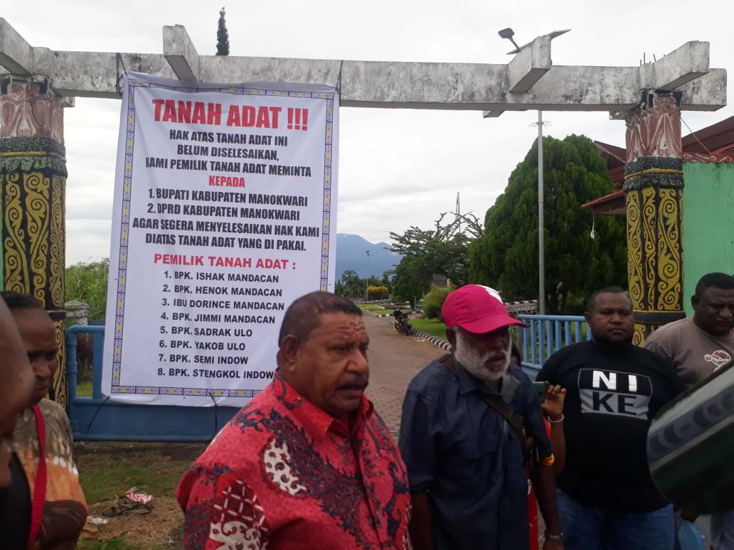 MINTA KEJELASAN: Sejumlah warga memasang baliho di kantor bupati dan DPRD Manokwari terkait penyelesaian tanah ada yang saat ini jadi lokasi kantor bupati dan DPR Manokwari, Rabu (10/2/21).   