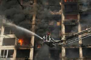 Petugas pemadam kebakaran berusaha memadamkan api di gedung apartemen yang rusak akibat penembakan di Kiev, Ukraina (Efrem Lukatsky/AP Photo)