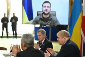 Perdana Menteri Inggris Boris Johnson serta Presiden Finlandia Sauli Niinisto dan hadirin bertepuk tangan setelah Presiden Ukraina Volodymyr Zelenskiy berbicara melalui tautan video, pada pertemuan para pemimpin Pasukan Ekspedisi Gabungan, sebuah koalisi