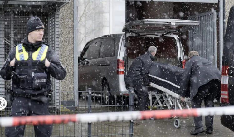 Petugas membawa jenazah korban penembakan di Aula Saksi Yehuwa, Hamburg, Jerman (Markus Schreiber/AP)