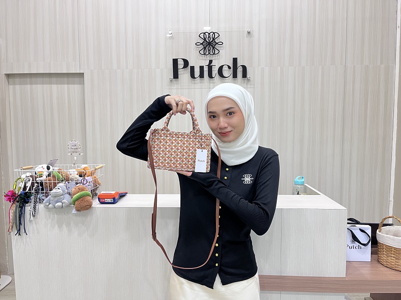 ISTIMEWA PRODUK LOKAL: Putri menunjukan produk tas hasil kerajinan tangan warga lokal.