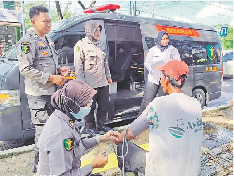 PATROLI KESEHATAN: Personel Bid Dokkes Polda Kaltim mengecek kesehatan masyarakat dan memberikan obat-obatan.&nbsp;&nbsp;