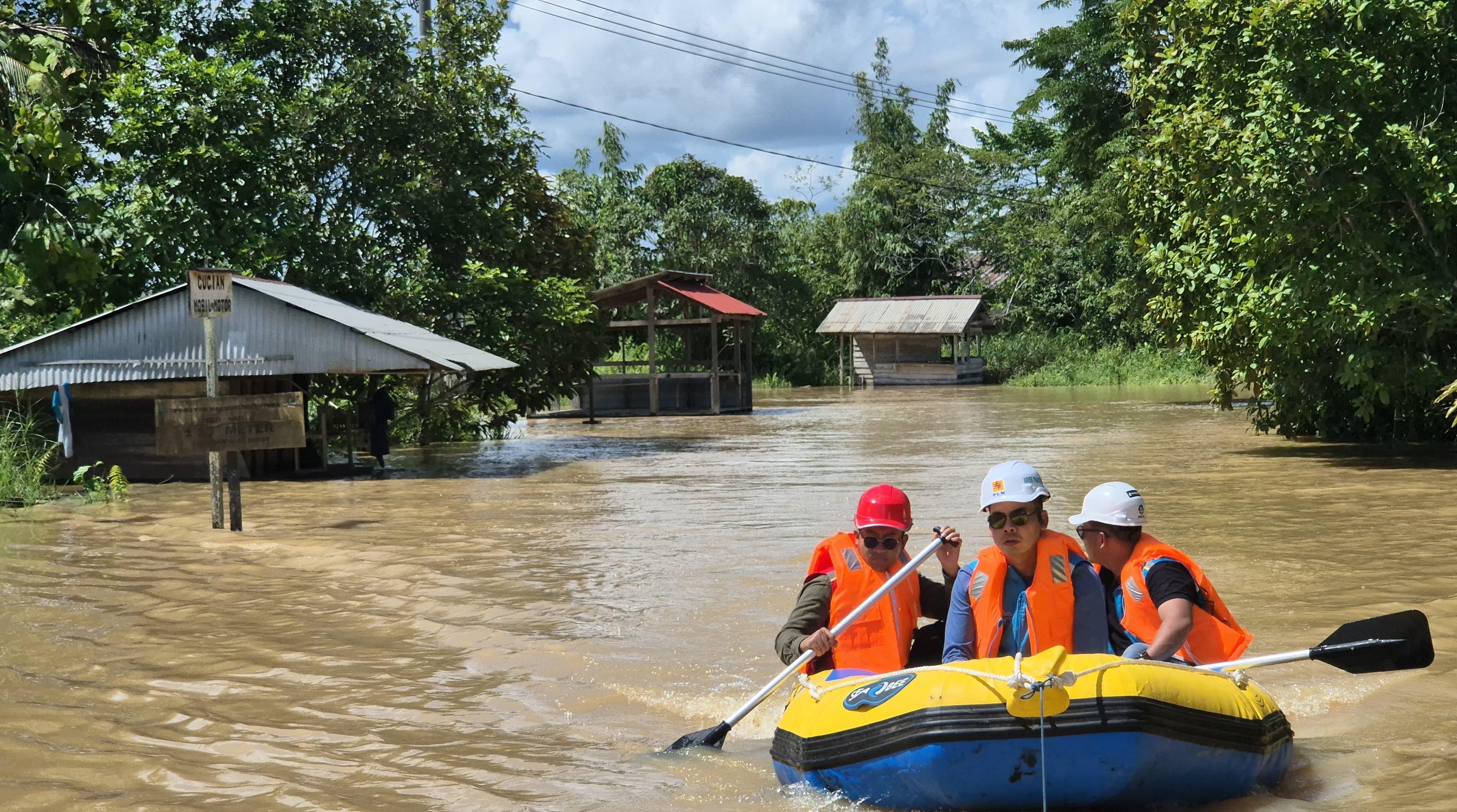 GERAK CEPAT : Petugas PLN menggunakan parahu karet mengamankan pasokan listrik.