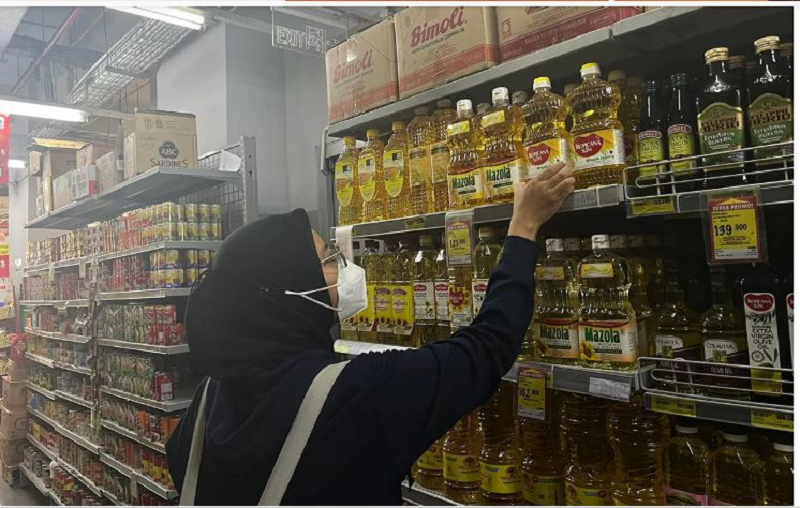 BATAL NAIK: Seorang wanita tengah membeli minyak goreng di sebuah minimarket di Jakarta, Rabu (1/1).