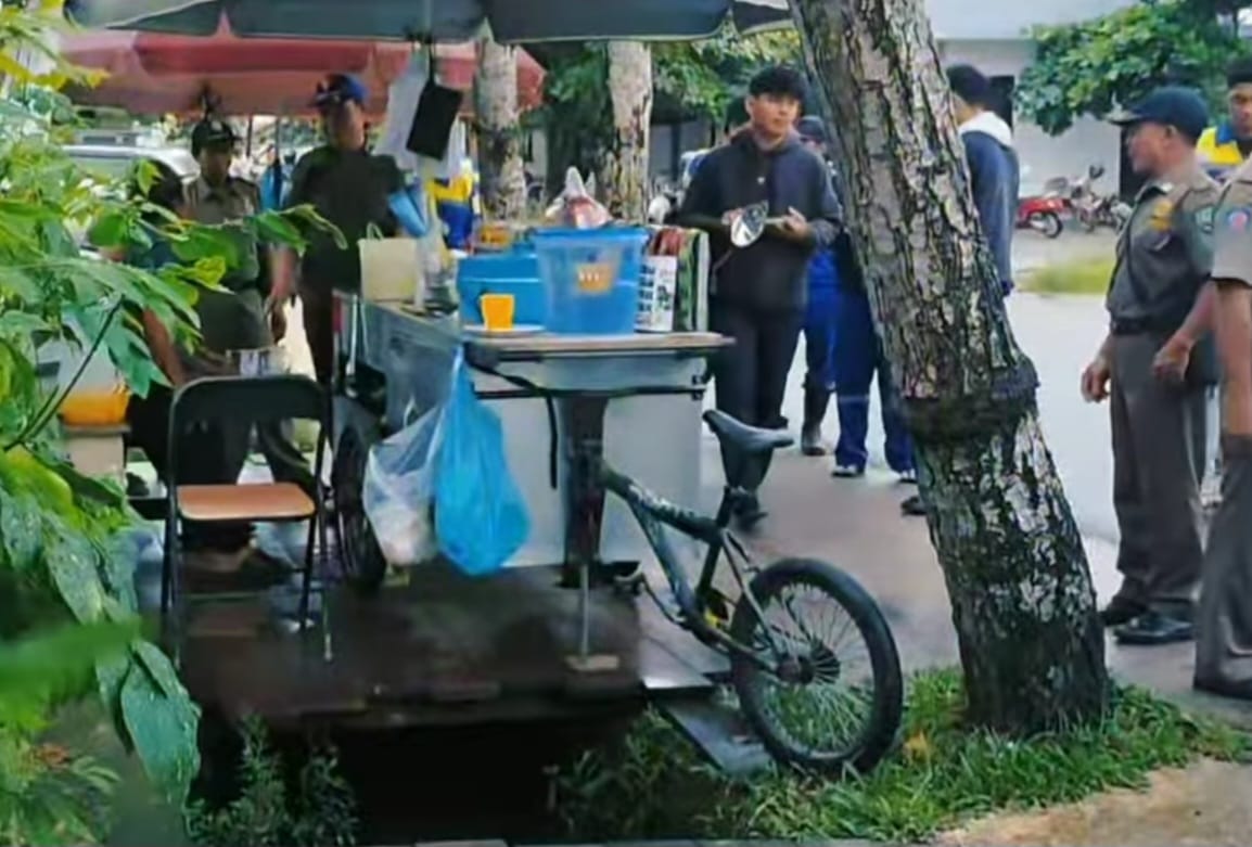 BERI IMBAUAN : Petugas memberikan imbauan kepada pedagang yang berjualan di atas drainase.