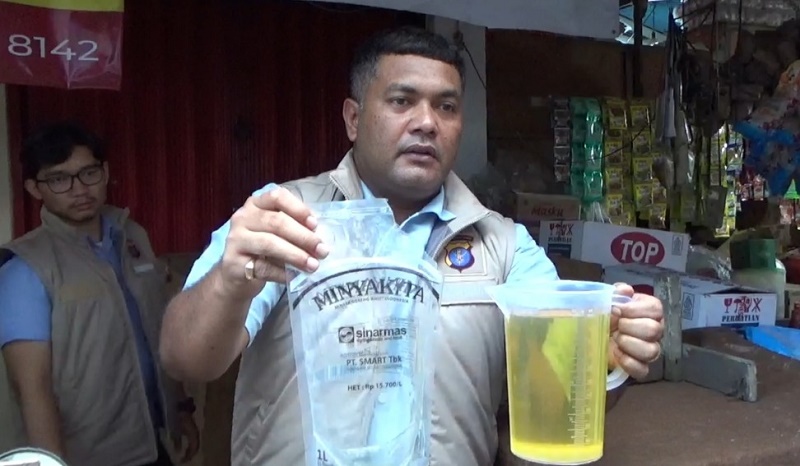 KP UJI TAKARAN: Petugas Satgas Pangan dari Ditreskrimsus Polda Kaltim mengecek penjualan dan kemasan minyak goreng.