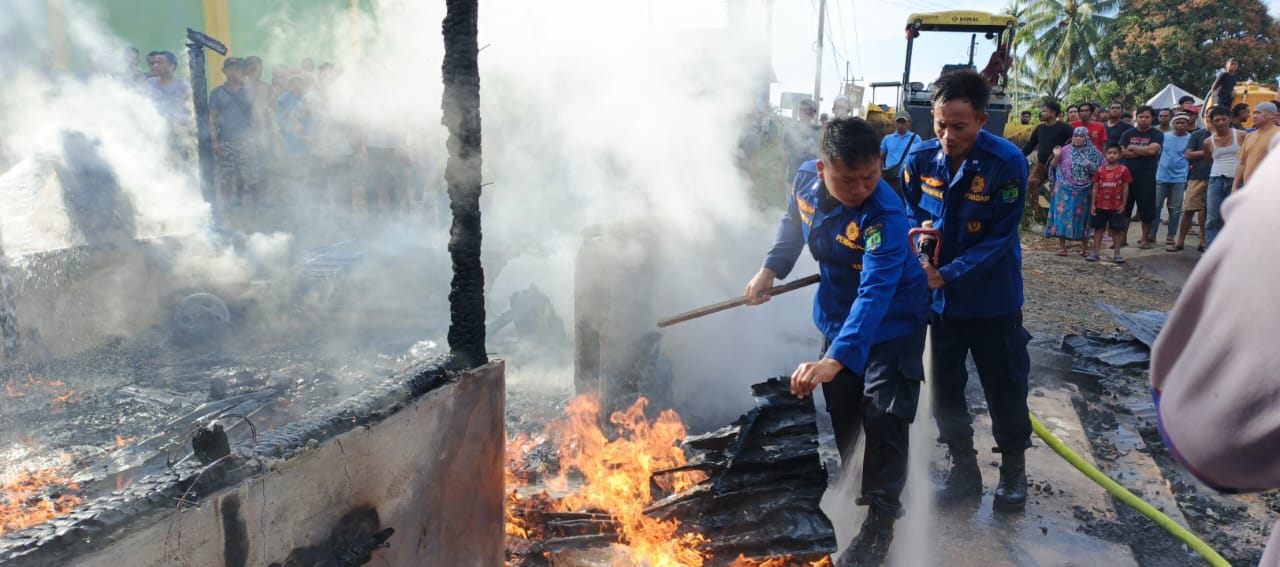 PADAMKAN API: Sejumlah petugas Disdamkar dan Penyelamatan saat berjibaku memadamkan api yang membakar rumah kios milik Salma di Tulin Onsoi, Minggu (20/4). FOTO: DOK DISDAMKAR NUNUKAN