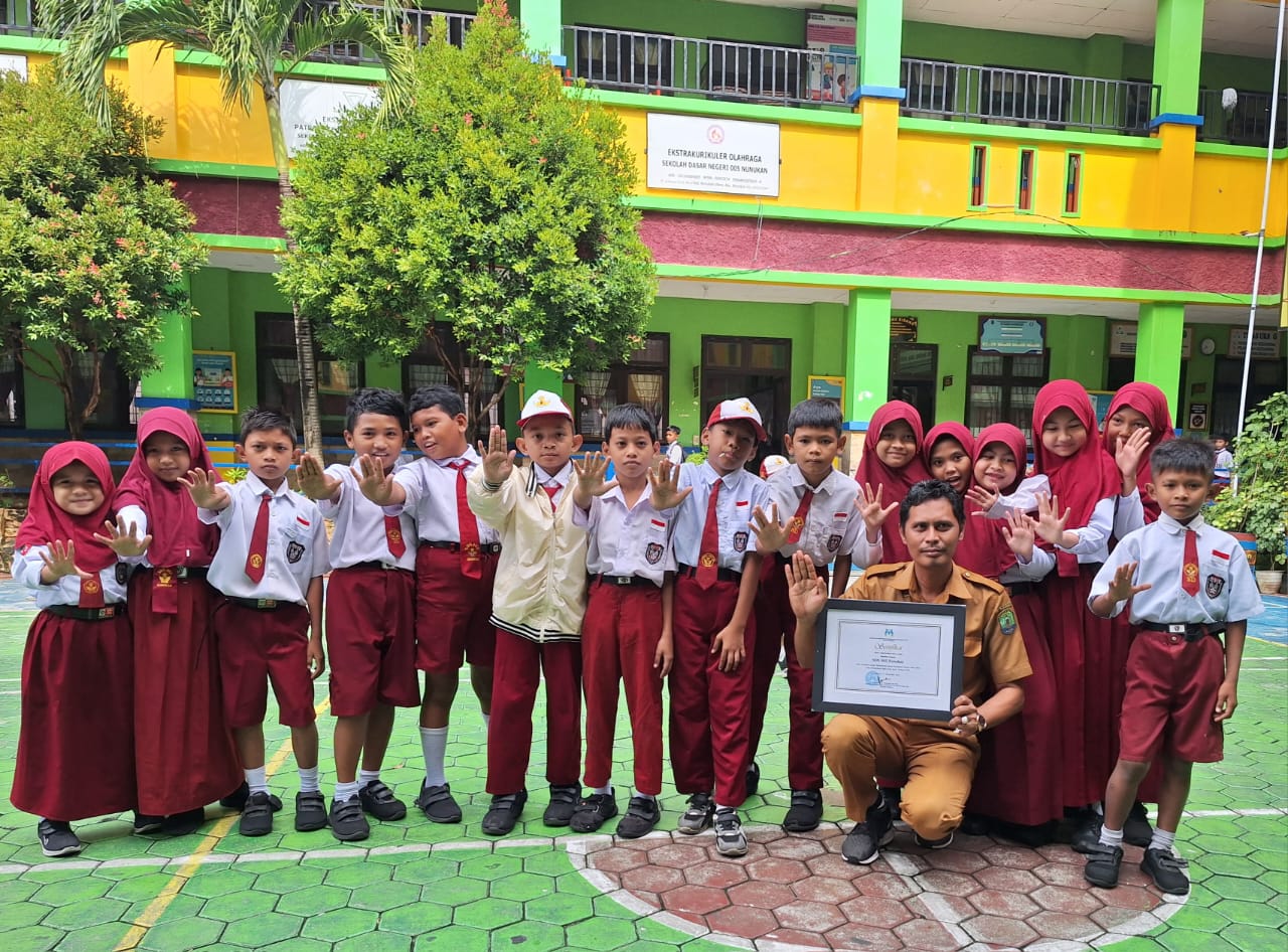 MEMBANGGAKAN: Kepala Sekolah SDN 005 Nunukan, Abdul Wahid bersama sejumlah siswa siswi memperhatikan sertifikat Satuan Ramah Anak (SRA) yang diberikan Kementerian Pemberdayaan Perempuan