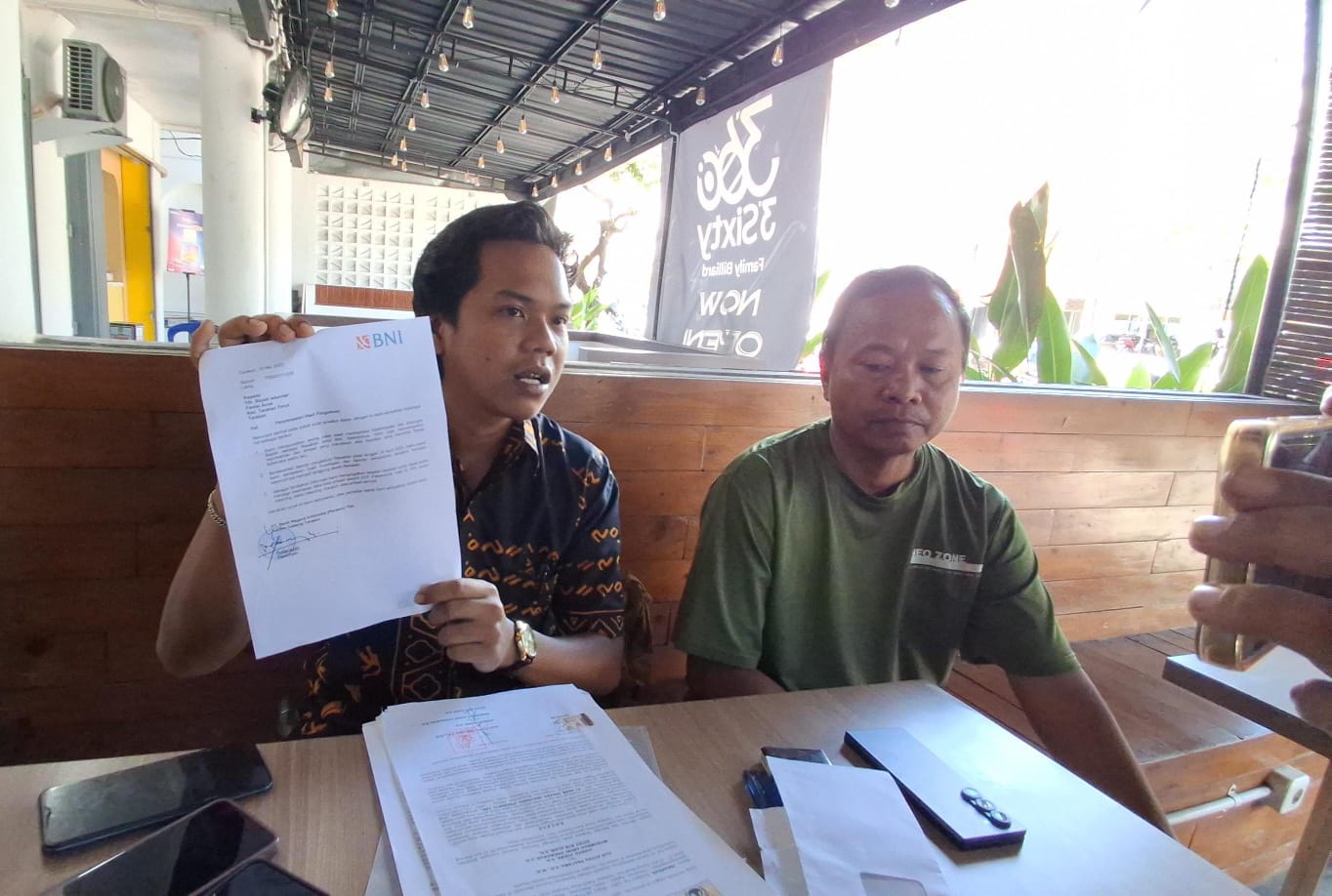 MEMPERLIHATKAN: Kuasa hukum Iskandar korban penipuan Rp 575 juta Alif Putra Pratama (kiri) menunjukkan hasil investigasi yang dinilai membingungkan. FOTO:&nbsp;AGUS DIAN ZAKARIA/RADAR TARAKAN