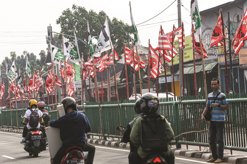 PARPOL: Pengendara melintas di deretan bendera parpol di pembatas jalan kawasan Pasar Minggu, Jakarta. (Miftahul Hayat)