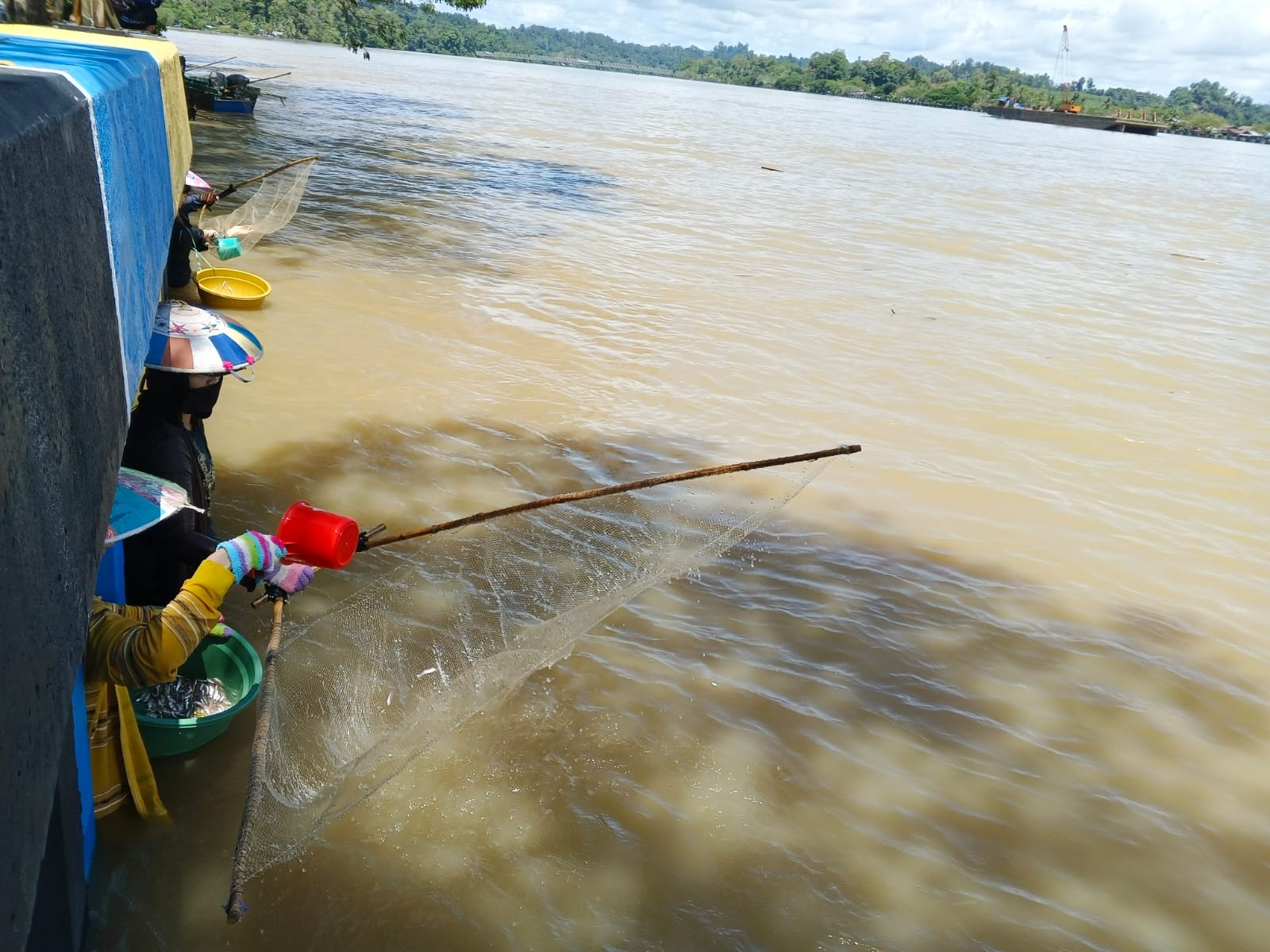 SEADANYA: Sejumlah warga mengais rezeki penanggung ikan seruyuk di bawah turap Sungai Kayan di Kampung Arab Tanjung Selor. FOTO: SOPIAN/RADAR TARAKAN