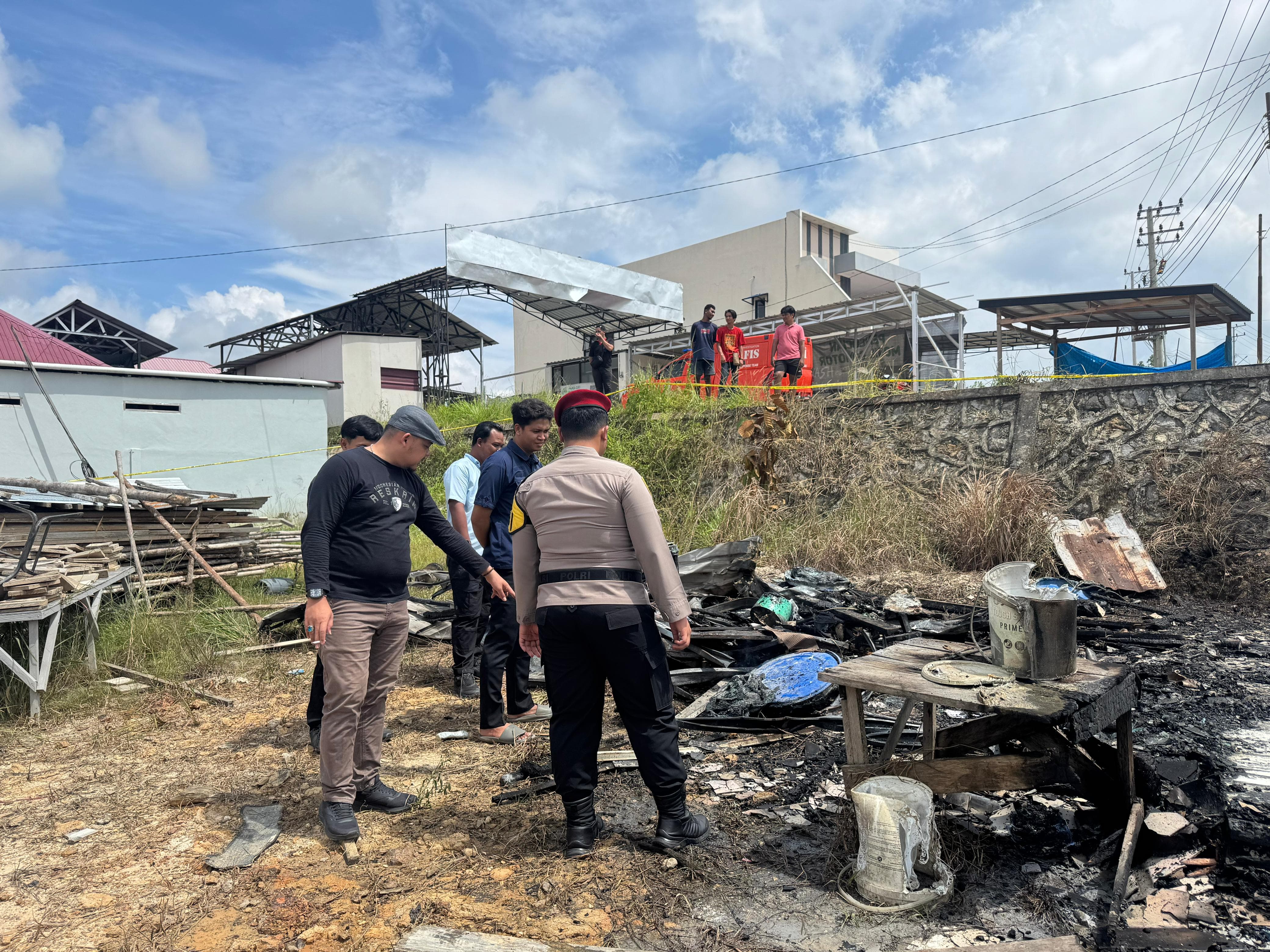TERBAKAR: Petugas kepolisian saat melakukan olah TKP.