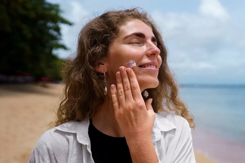 Perempuan mengaplikasikan sunscreen. (Freepik)