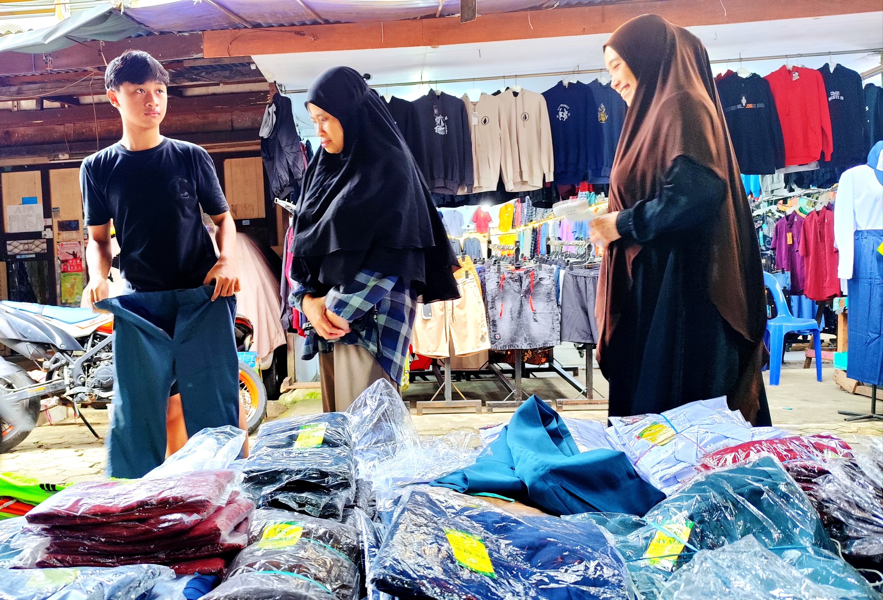 MENURUN: Seorang ibu bersama anaknya saat membeli seragam sekolah di Pasar THM.FOTO:&nbsp;NATANAEL/RADAR TARAKAN