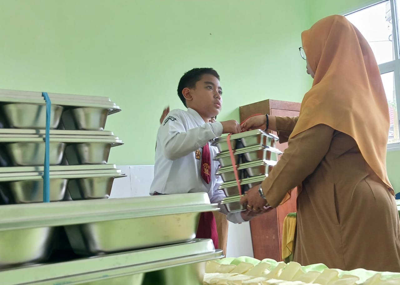 MENERIMA: Siswa SD menerima paket menu MBG yang diberikan oleh guruFOTO:&nbsp;AGUS DIAN ZAKARIA/RADAR TARAKAN