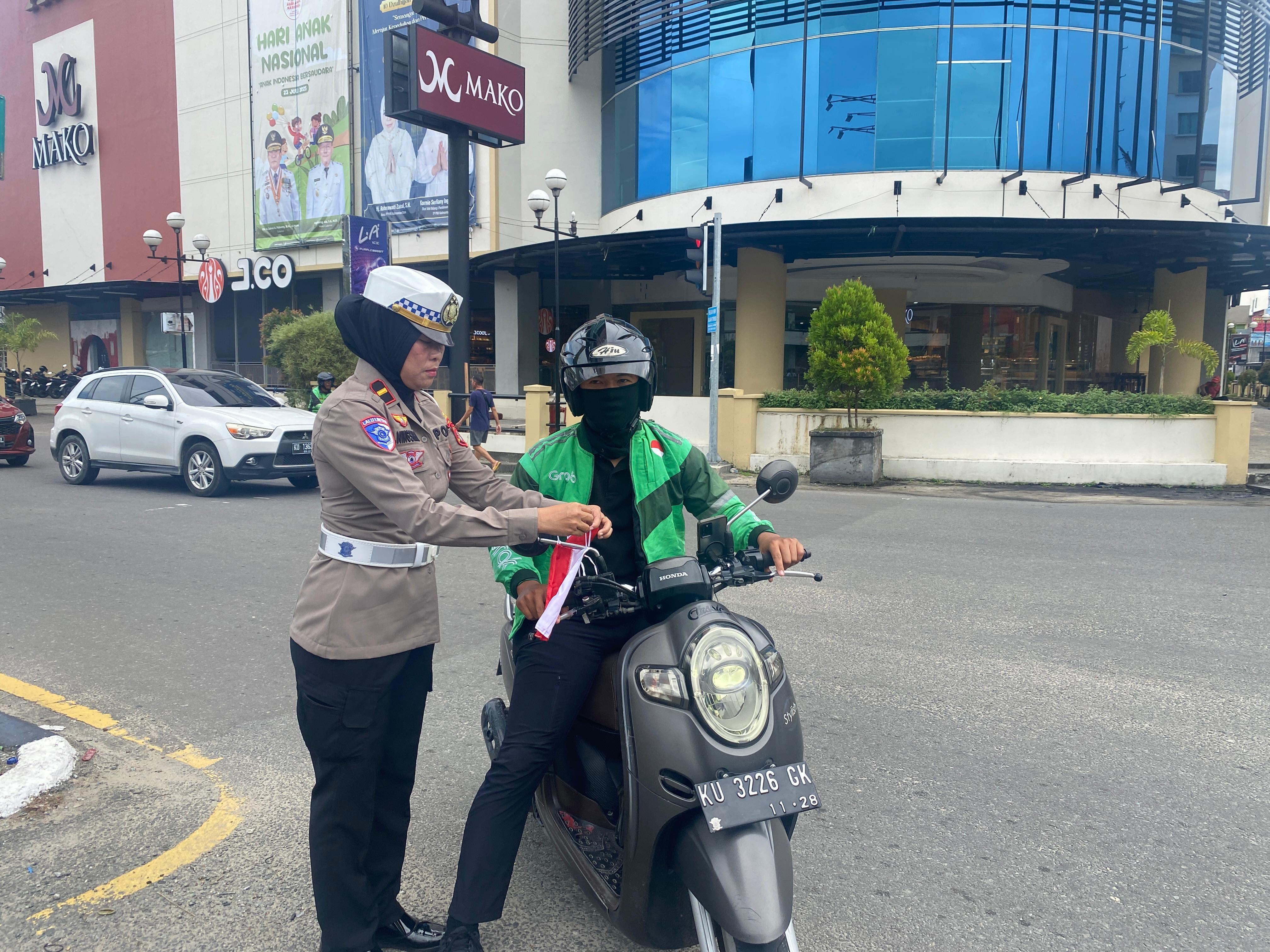 MEMASANG : Personel Satlantas Polres Tarakan memasang bendera Merah Putih di seluruh kendaraan jelang HUT RI ke 80.FOTO:&nbsp;SATLANTAS POLRES TARAKAN