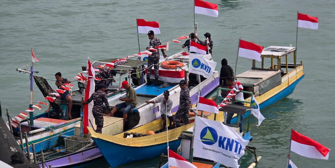 BERBAGI BENDERA: Sejumlah nelayan yang melaut mengibarkan langsung bendera merah putih setelah dibagikan oleh prajurit KRI Ajak-653 Satkat Koarmada II. FOTO: DOK LANAL NUNUKAN