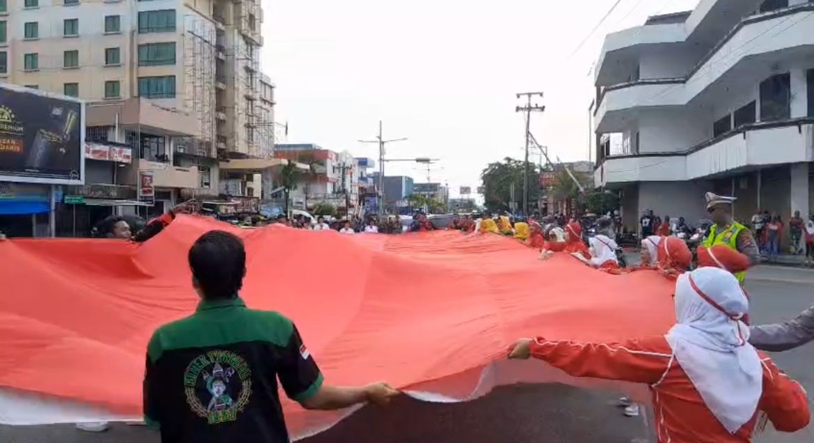 BENTANGKAN BENDERA : Bendera merah putih berukuran 17 meter x 8 meter itu dibentangkan di perempatan GTM, FOTO:ELIAZAR/RADAR TARAKAN
