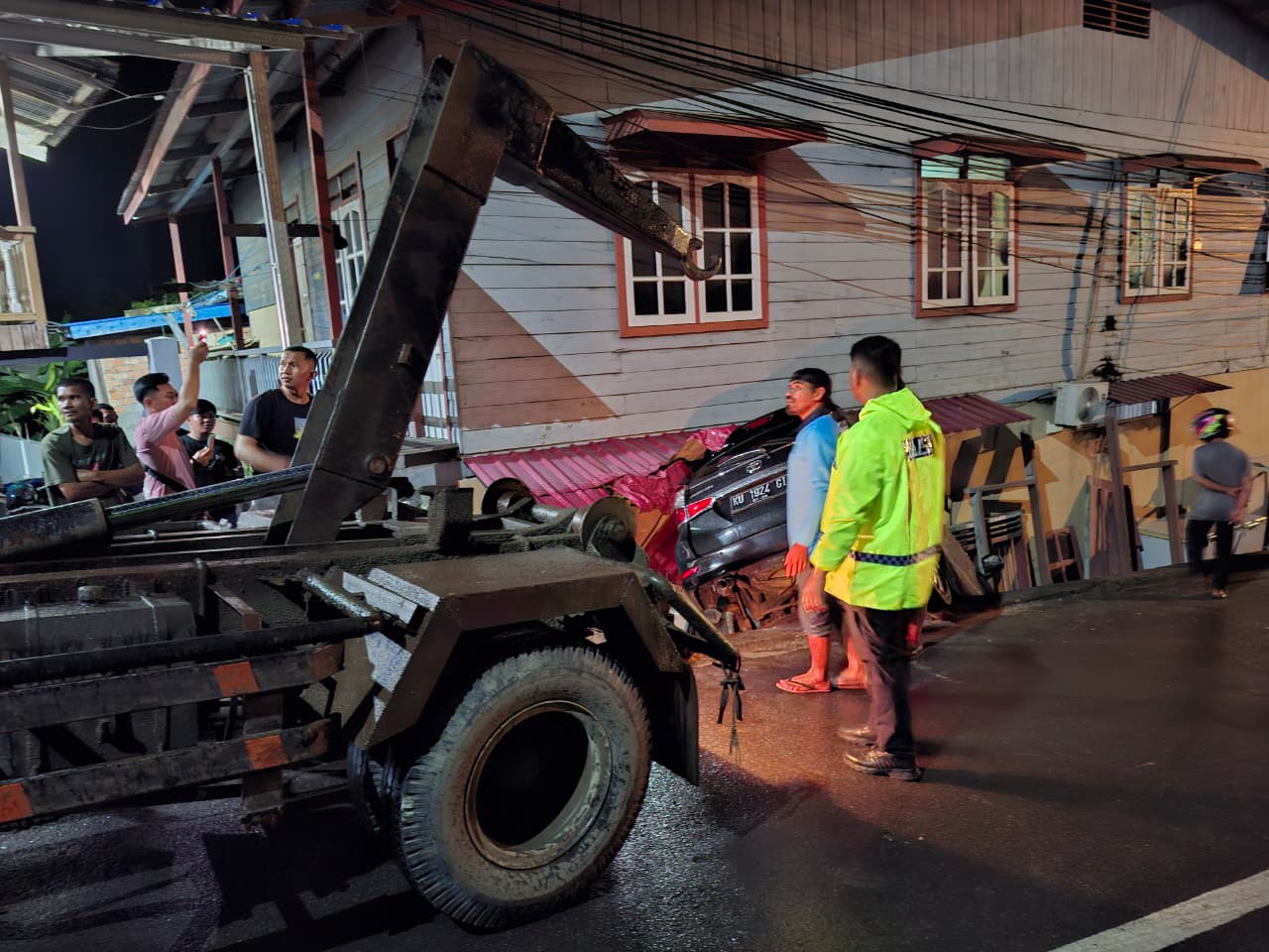 PROSES EVAKUASI: Petugas terlihat berusaha memindahkan mobil yang nyungsep ke rumah warga FOTO:DOK POLRES NUNUKAN  &nbsp;