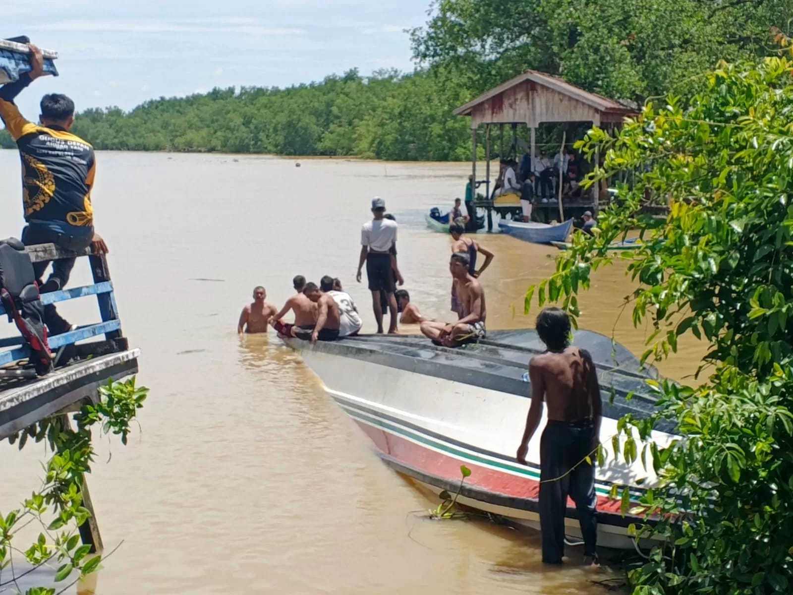 TERBALIK: Masyarakat bersama ABK kapal berusaha membalikan speedboat yang mengalami lama, FOTO:SOPIAN/RADAR TARAKAN