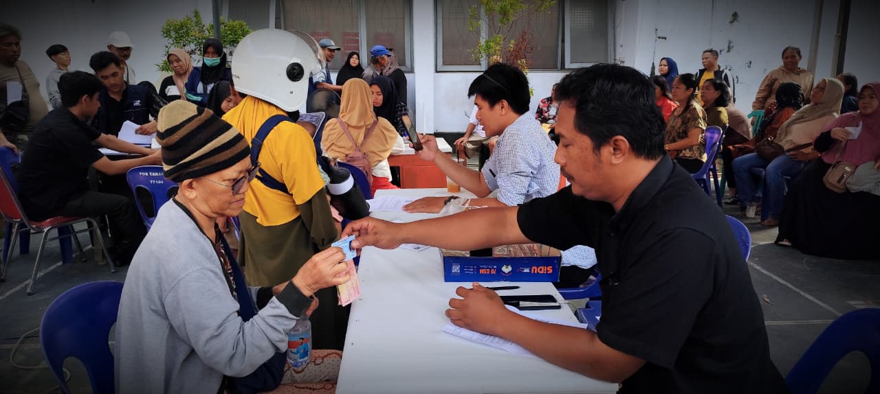 NATANAEL/RADAR TARAKAN BANTUAN: Petugas Pos memberikan uang tunai bantuan BLTS