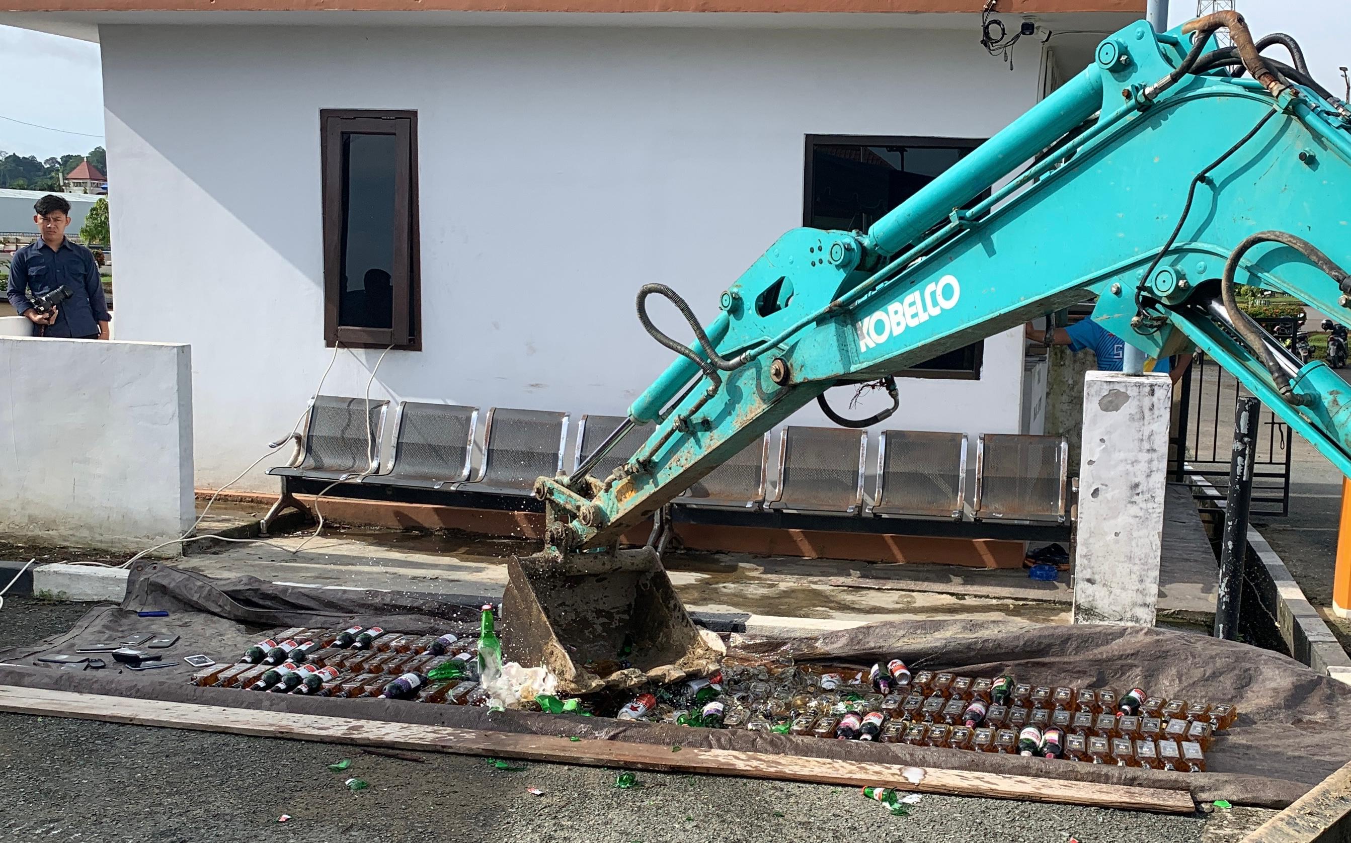 MIRAS: Pemusnahan ratusan minuman keras dari berbagai merek menggunakan alat berat ekskavator.