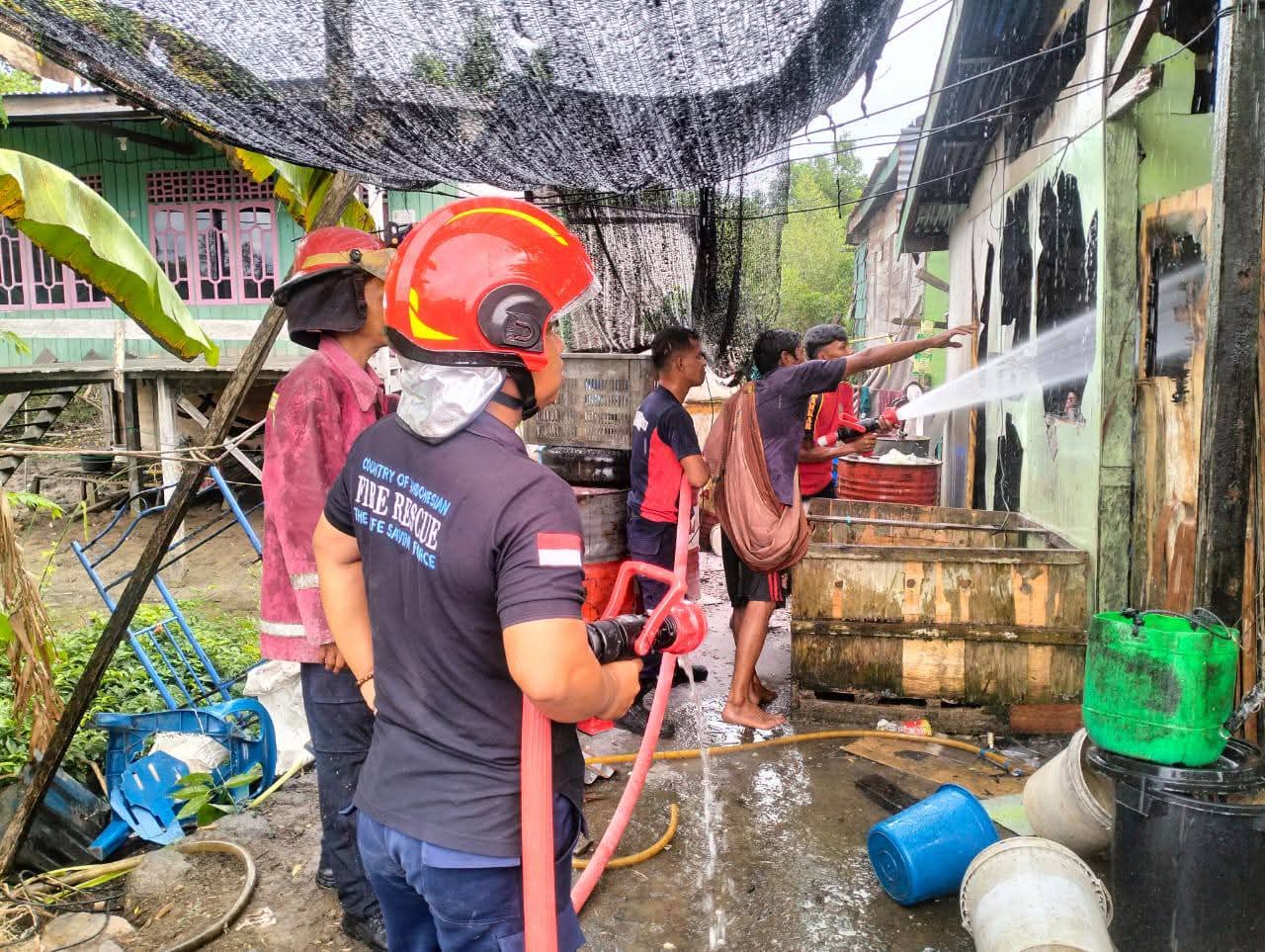 PENDINGINAN: Petugas damkar melakukan penyemprotan air meski api sudah padam untuk memastikan api benar-benar mati.