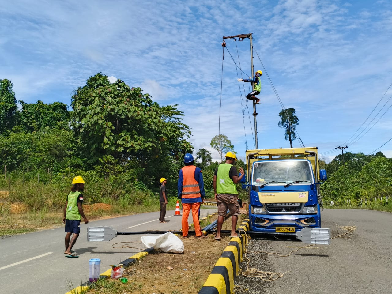 TAMBAH PJU: Pekerja sedang memasang PJU dekoratif di jalan utama Desa Sebawang, Kamis (19/12).