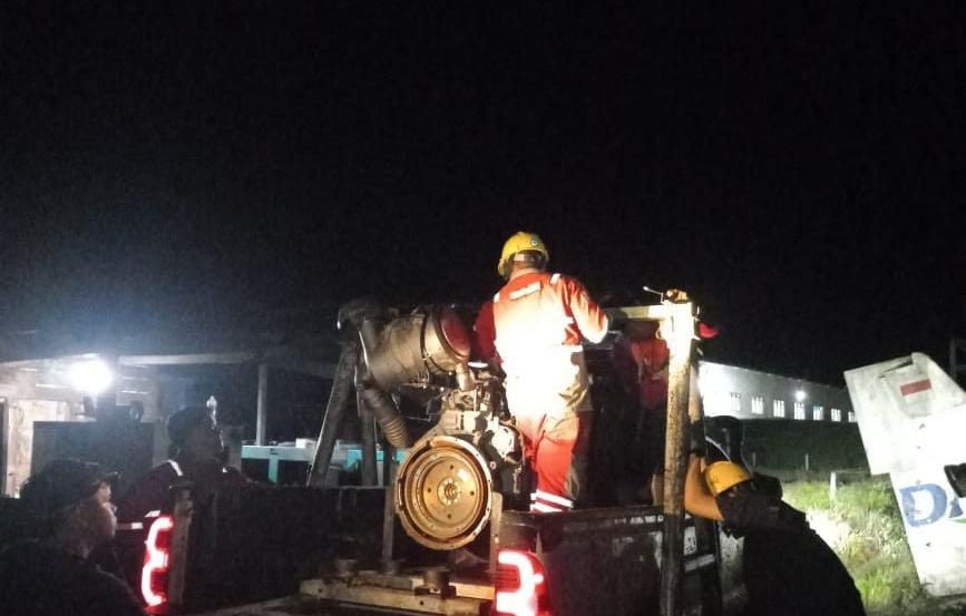 KERJA SAMA: Proses penurunan mesin dari mobil ke posisi mesin di lokasi PLN Long Layu, Krayan Selatan.