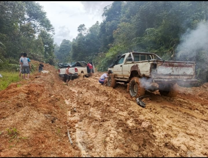 RUSAK: Kendaraan yang mengangkut barang saat melintas dari Krayan Barat menuju Selatan tertahan karena kondisi jalan sulit dilalui.