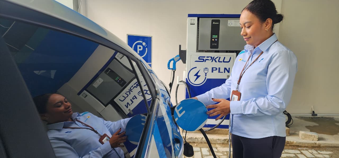 PENGISIAN DAYA: Petugas PLN mengisi daya mobil listrik di SPKLU.