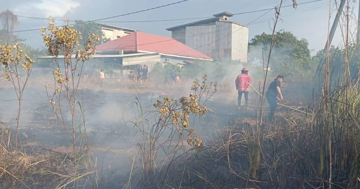 PEMADAMAN : Personel Damkar Sektor Lumbis melakukan upaya pemadaman api yang membakar lahan warga.