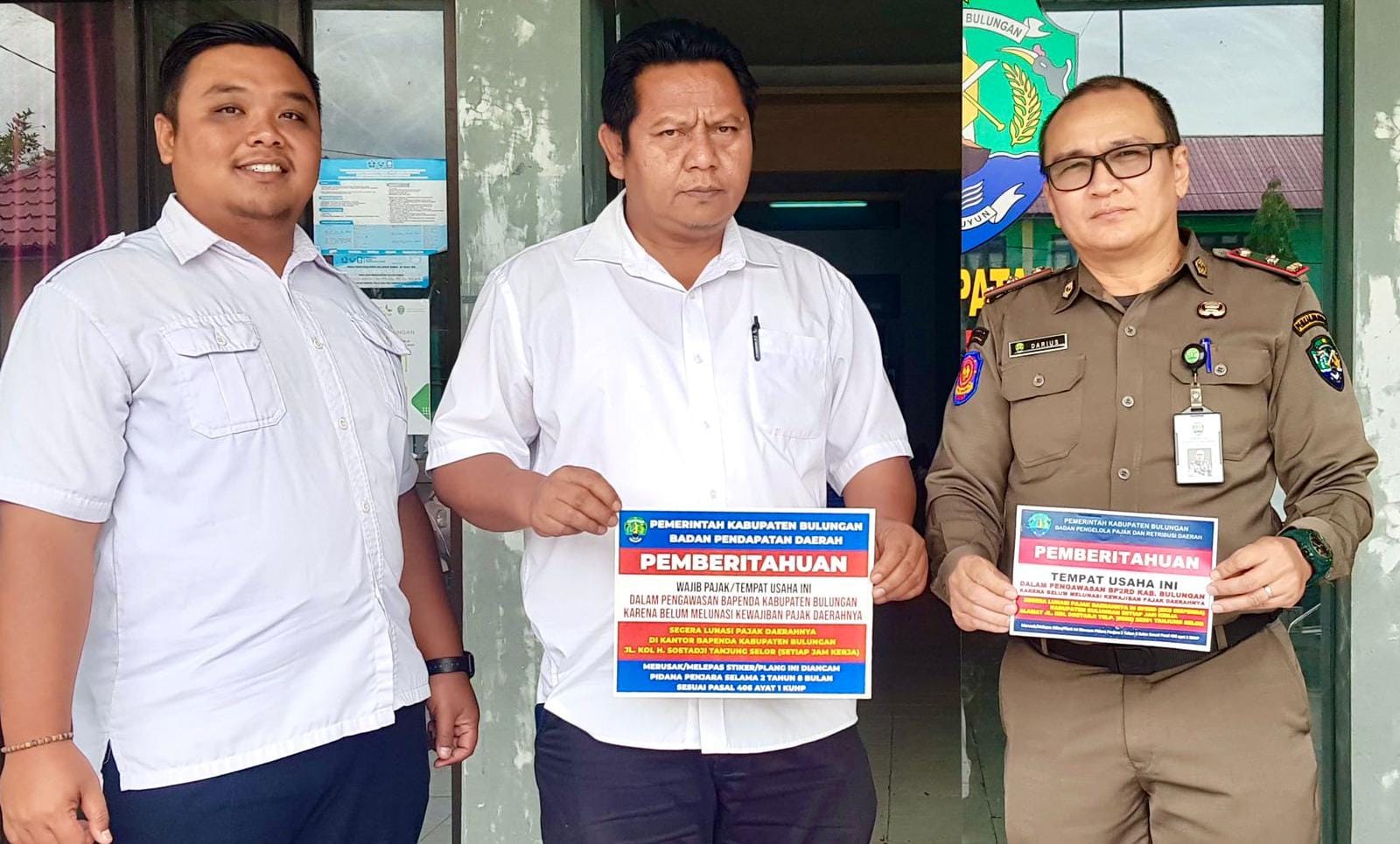 STIKER: Petugas memperlihatkan stiker untuk wajib pajak yang bandel.